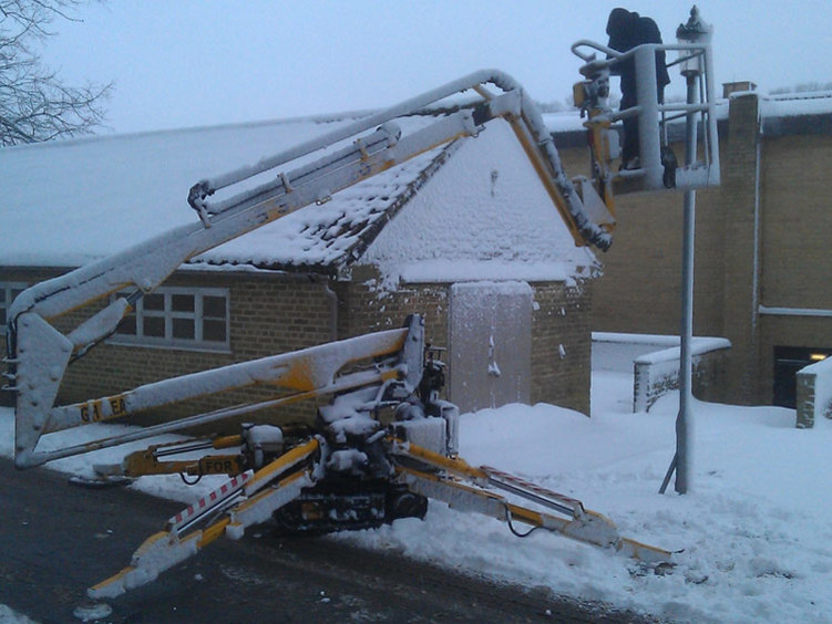 Sabrina tracked spiderlift cherrypicker from High Reaching Solutions covered in snow doing street lighting repairs Malton York Yorkshire